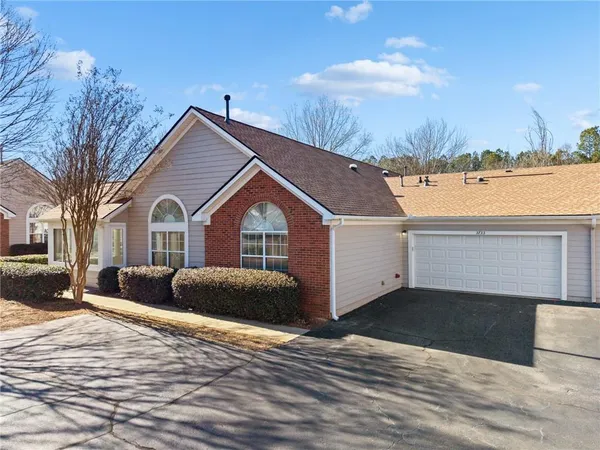 a front view of a house with a yard and mountain view in back