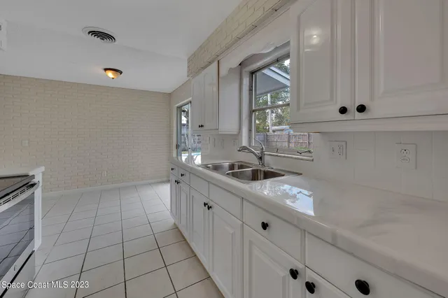 a kitchen with granite countertop white cabinets and white appliances