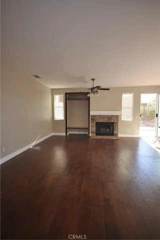 a view of empty room with fireplace and wooden floor