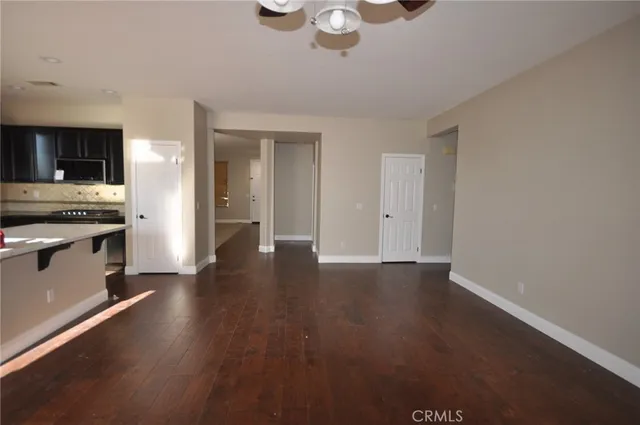 an empty room with wooden floor sink and windows