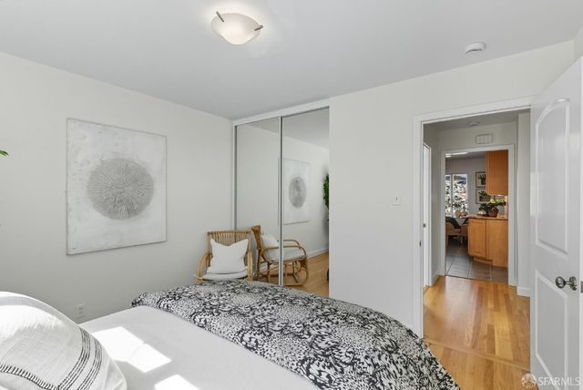 a bedroom with a bed and a view of living room