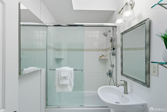 a bathroom with a shower sink and mirror