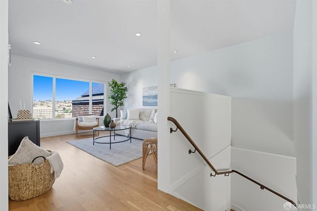 a living room with furniture a rug and kitchen view