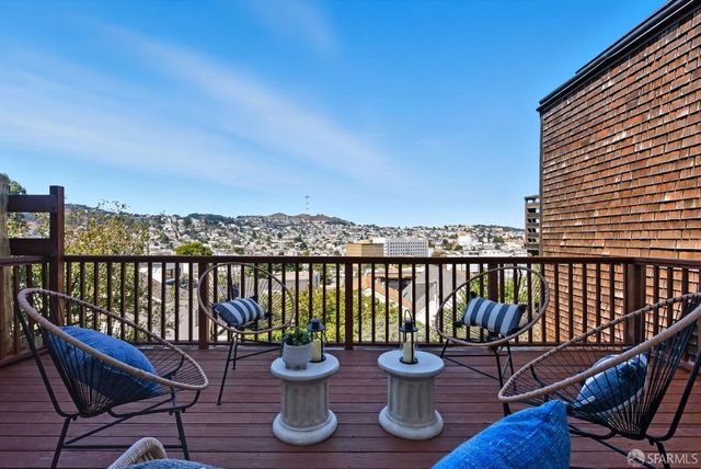 a view of a balcony with chairs and wooden floor