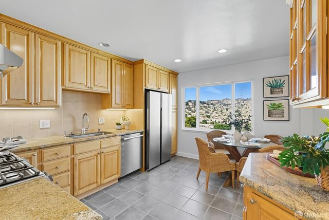 a kitchen with stainless steel appliances kitchen island granite countertop a sink and cabinets