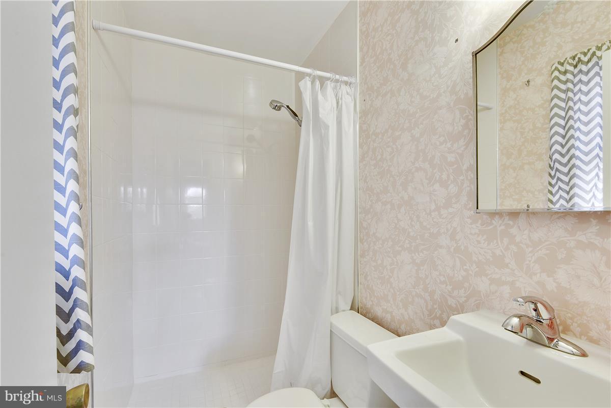 5901 Folkstone Road Bethesda, MD 20817 - Photo 13 of 30 a bathroom with a sink and shower