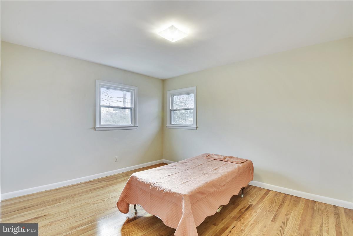 5901 Folkstone Road Bethesda, MD 20817 - Photo 14 of 30 a bedroom with a bed and wooden floor