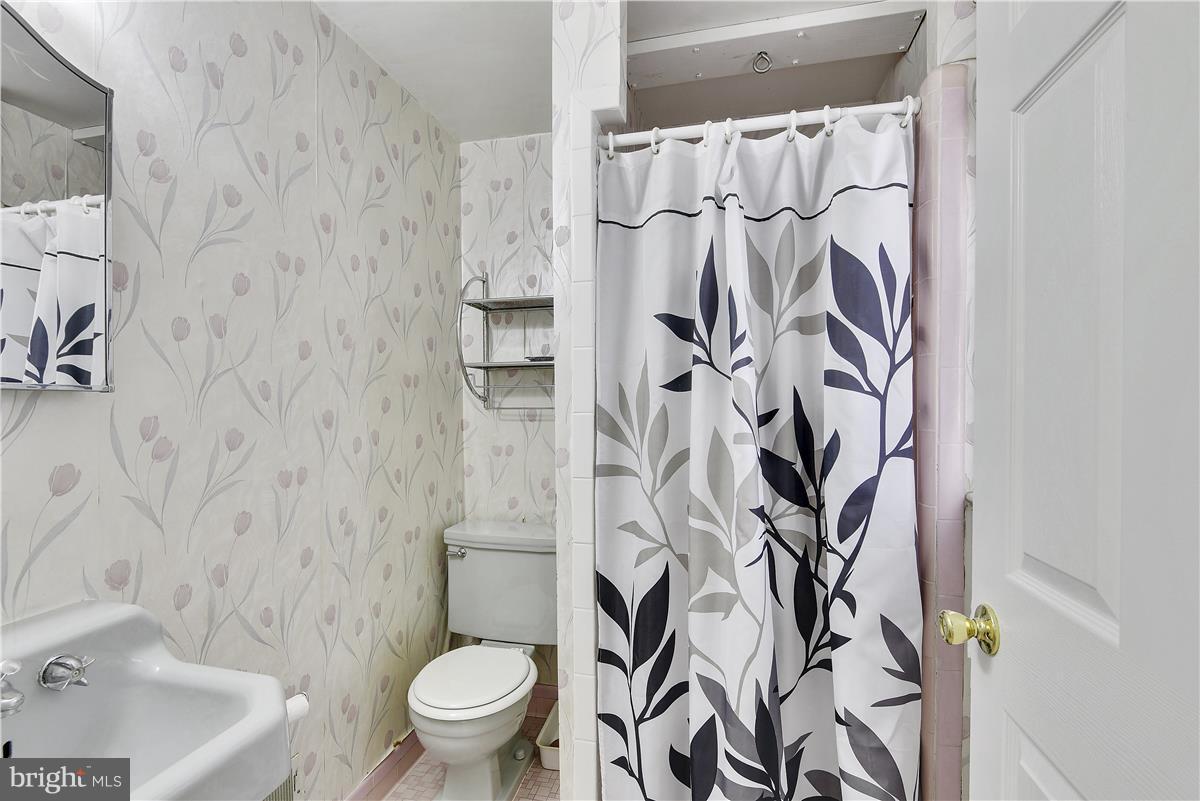 5901 Folkstone Road Bethesda, MD 20817 - Photo 21 of 30 a white toilet sitting next to a bathroom sink