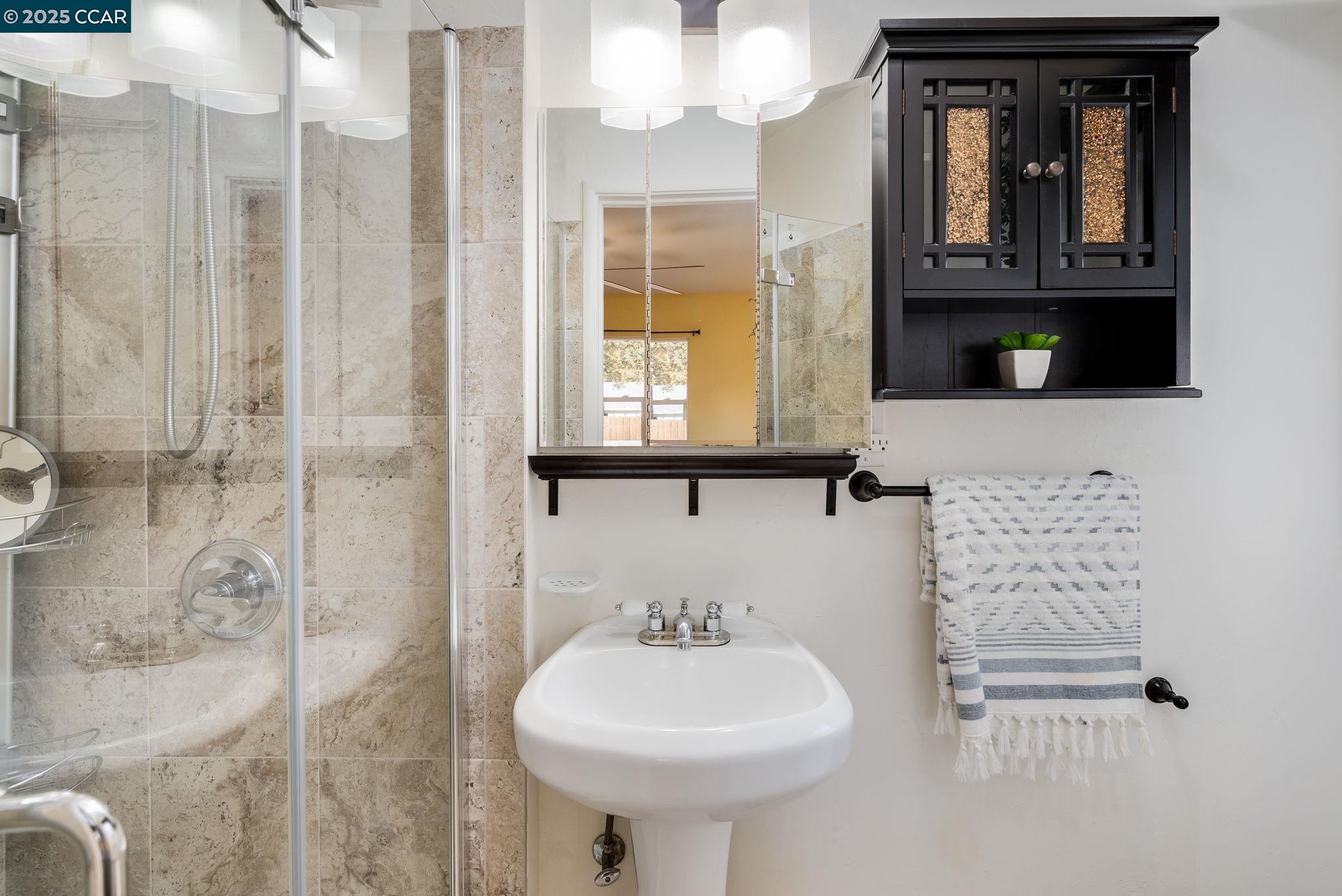2941 Crawford Street Concord, CA 94518 - Photo 14 of 27 a bathroom with a sink a mirror and a shower