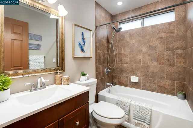 a bathroom with a sink a toilet a mirror and shower