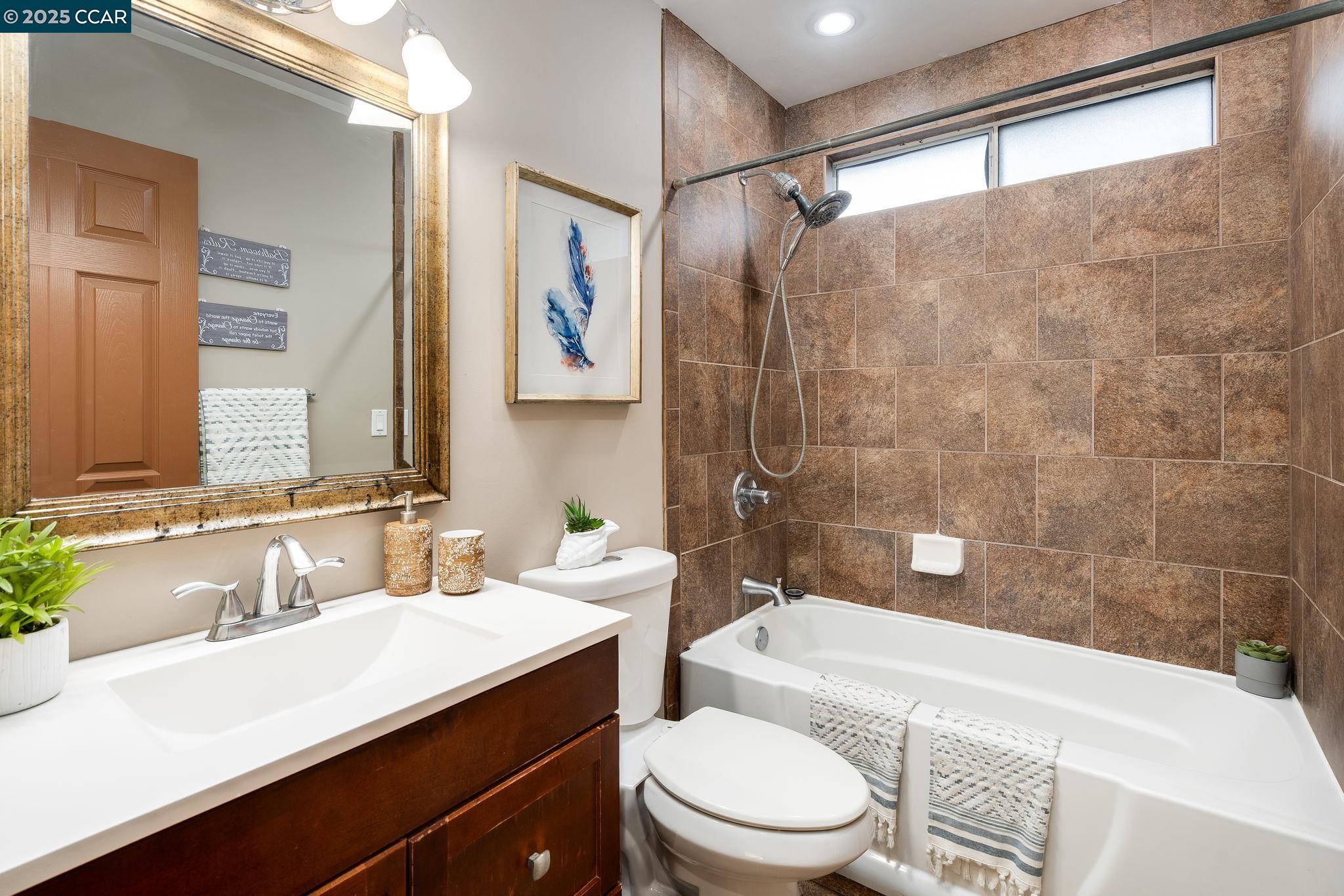 2941 Crawford Street Concord, CA 94518 - Photo 19 of 27 a bathroom with a sink a toilet a mirror and shower