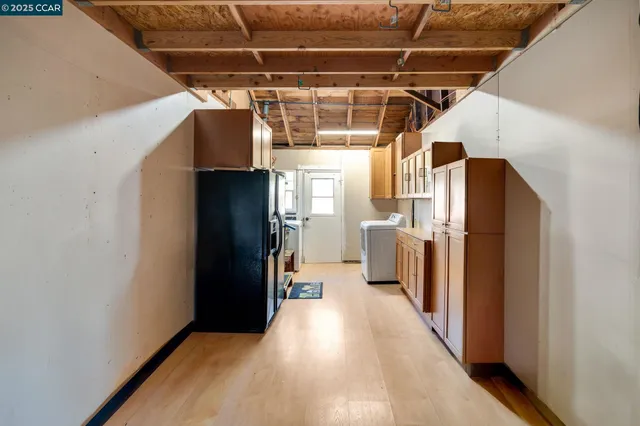 a view of a refrigerator in kitchen and a window