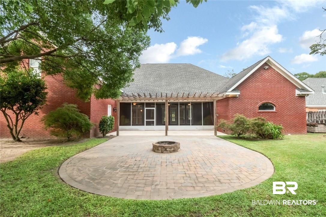 8837 Dawes Lake Road South Mobile, AL 36619 - Photo 15 of 44 Back of property with a lawn, a patio area, a fire pit, and a sunroom