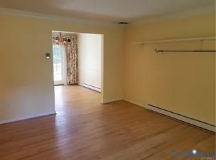 a view of a room with wooden floor and a window