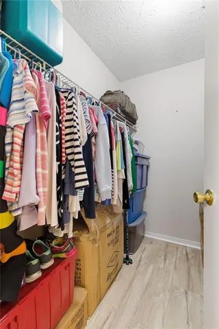 a view of walk in closet with clothes and shoes