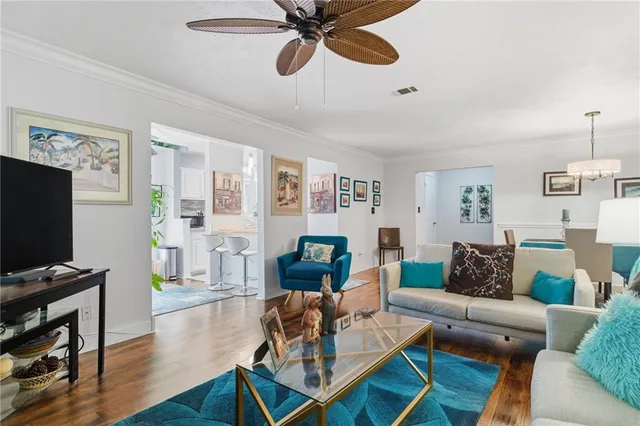 a living room with furniture and a flat screen tv with wooden floor