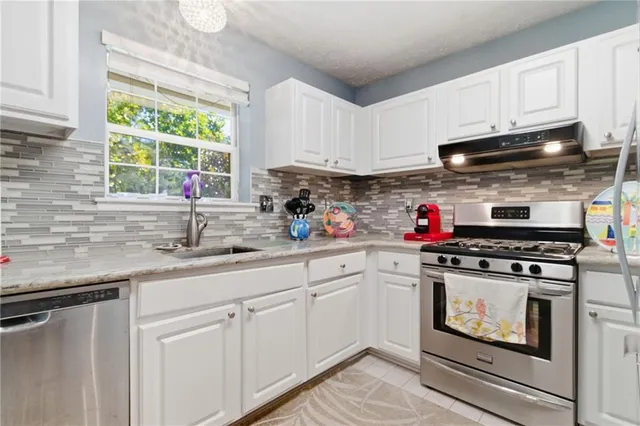 a kitchen with cabinets stainless steel appliances a sink and a window