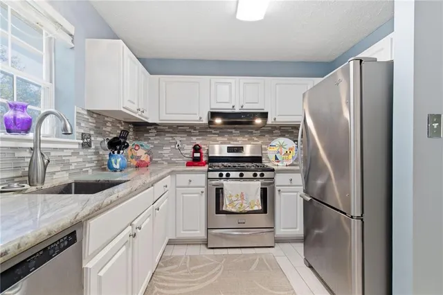 a kitchen with stainless steel appliances granite countertop a refrigerator sink and cabinets