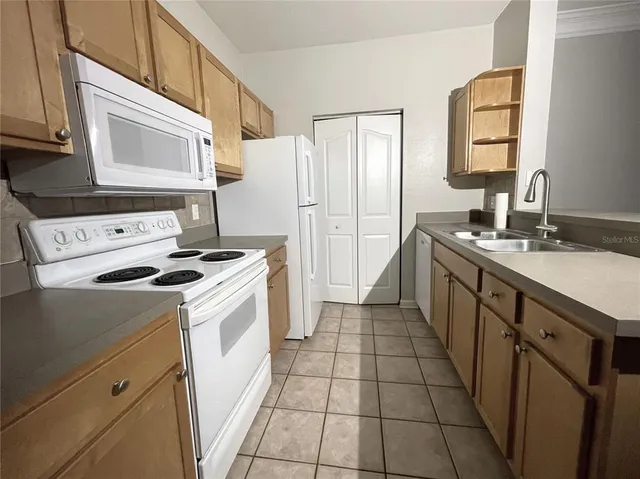 a kitchen with a stove sink and cabinets