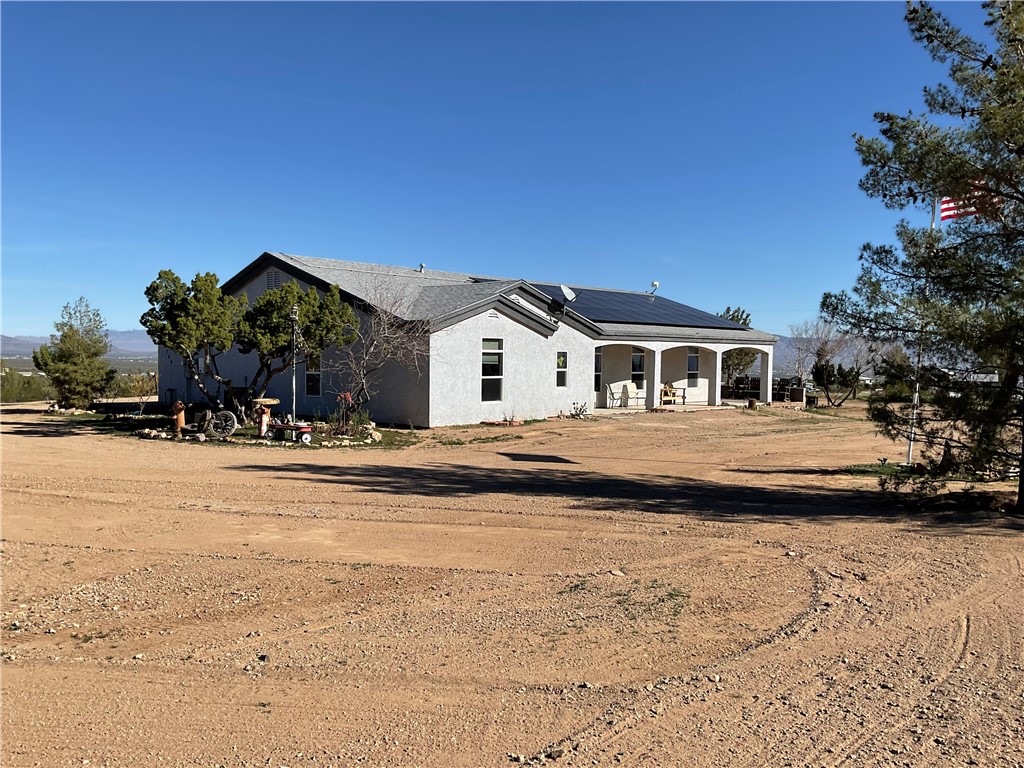 1790 Gleeson Road Golden Valley, AZ 86413 - Photo 3 of 62 Rear view of property featuring roof mounted solar panels and a patio area