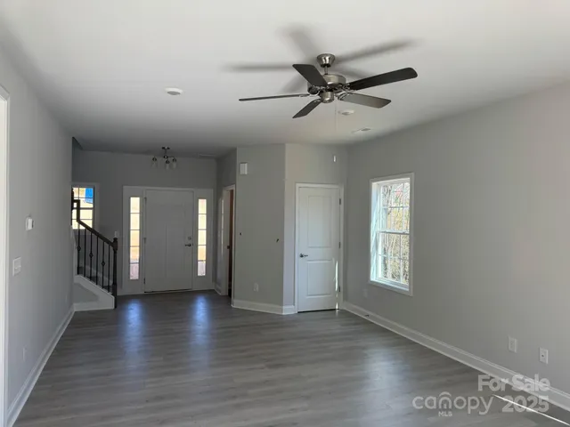 a view of a hallway with wooden floor and a ceiling fan