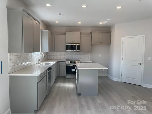 a kitchen with a sink cabinets and wooden floor