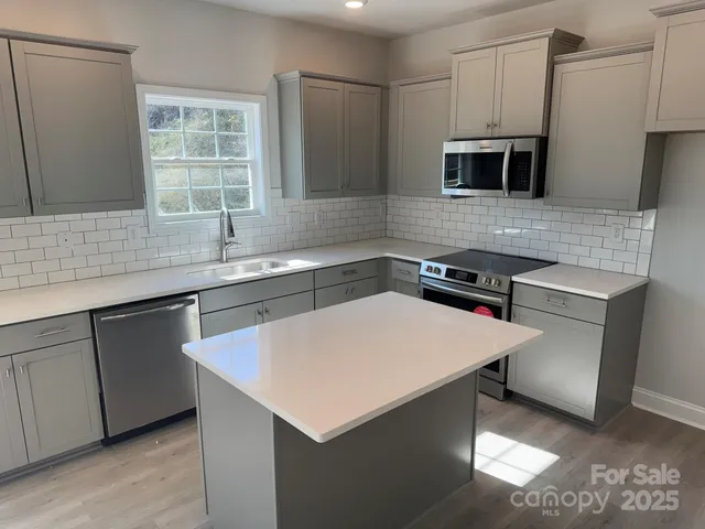 a kitchen with stainless steel appliances a sink a microwave a stove and refrigerator