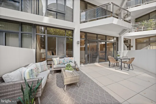 a view of a patio with couches table and chairs and potted plants