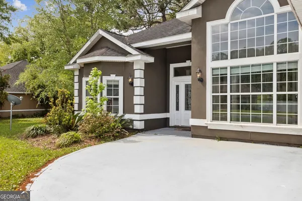 a front view of a house with a garden