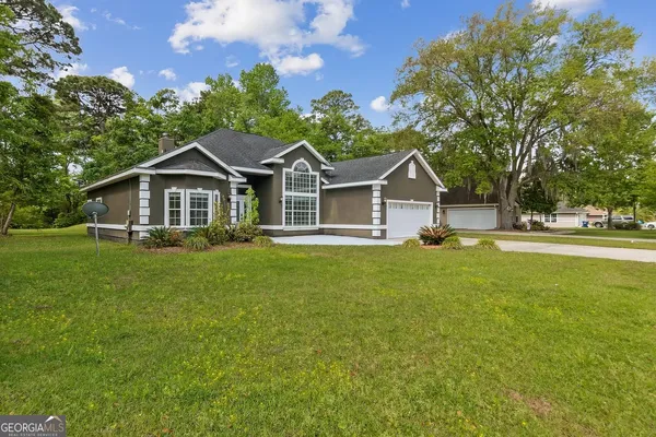 a front view of a house with yard and green space