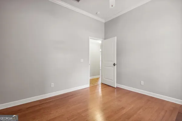 an empty room with wooden floor and white walls