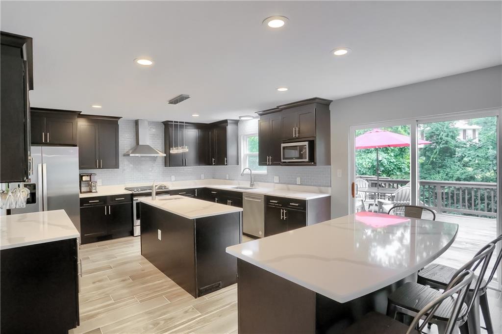 1075 Rural Ridge Drive Cheswick, PA 15024 - Photo 5 of 25 Two large islands provide extra counter space for meal prep and clean up and also a bright casual dining area with access tot he rear deck and wooded yard.