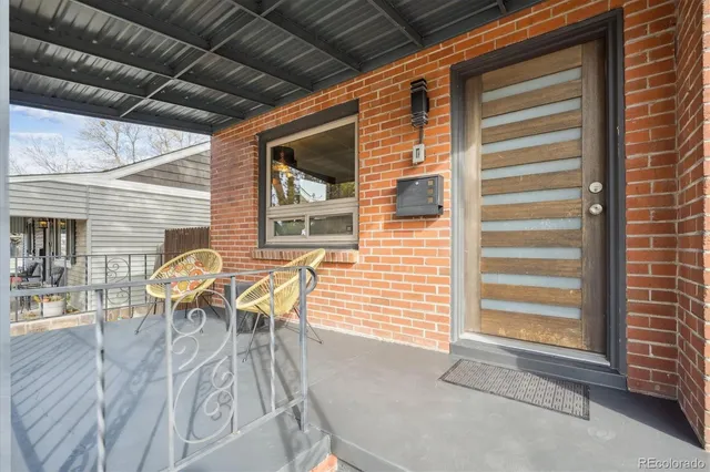 a patio with table and chairs and potted plants