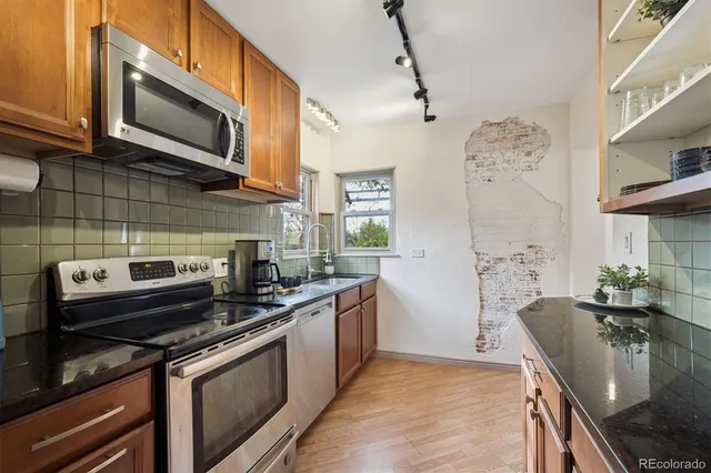 a kitchen with stainless steel appliances granite countertop a sink stove and microwave
