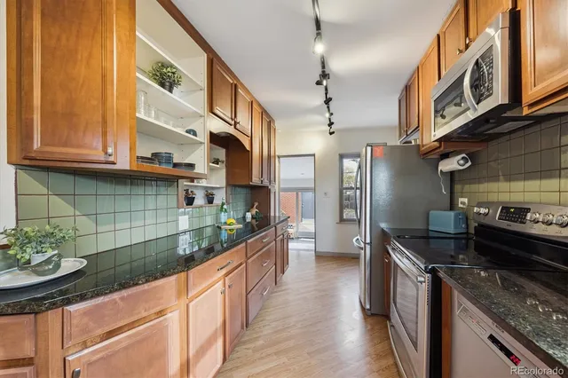 a kitchen with stainless steel appliances granite countertop a sink and a stove