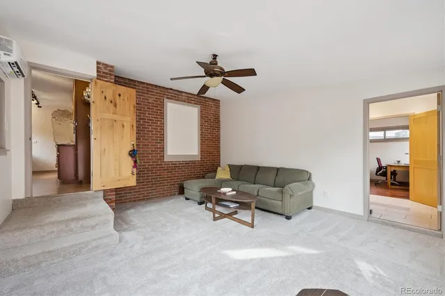 a living room with furniture and a ceiling fan