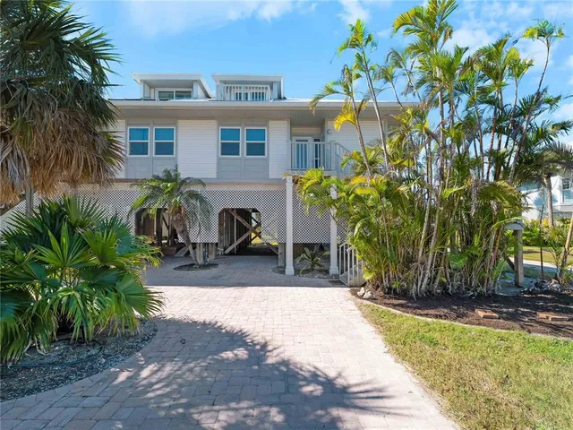 a view of a house with wooden walls and flower plants