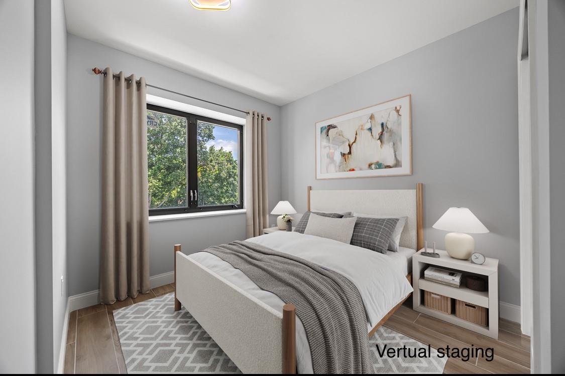 132-25 41st Avenue, Unit 5B Queens, NY 11355 - Photo 9 of 11 a bedroom with a bed a rug and a window