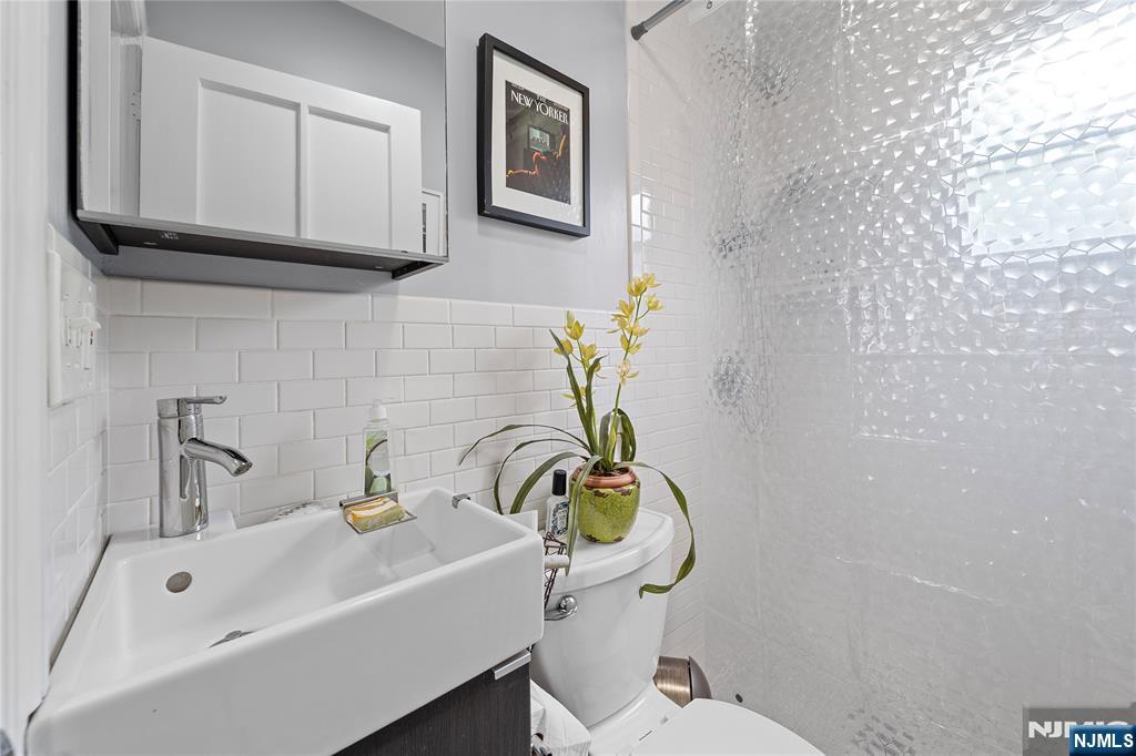 5 Leo Terrace Bloomfield, NJ 07003 - Photo 24 of 32 a bathroom with a sink a toilet and mirror