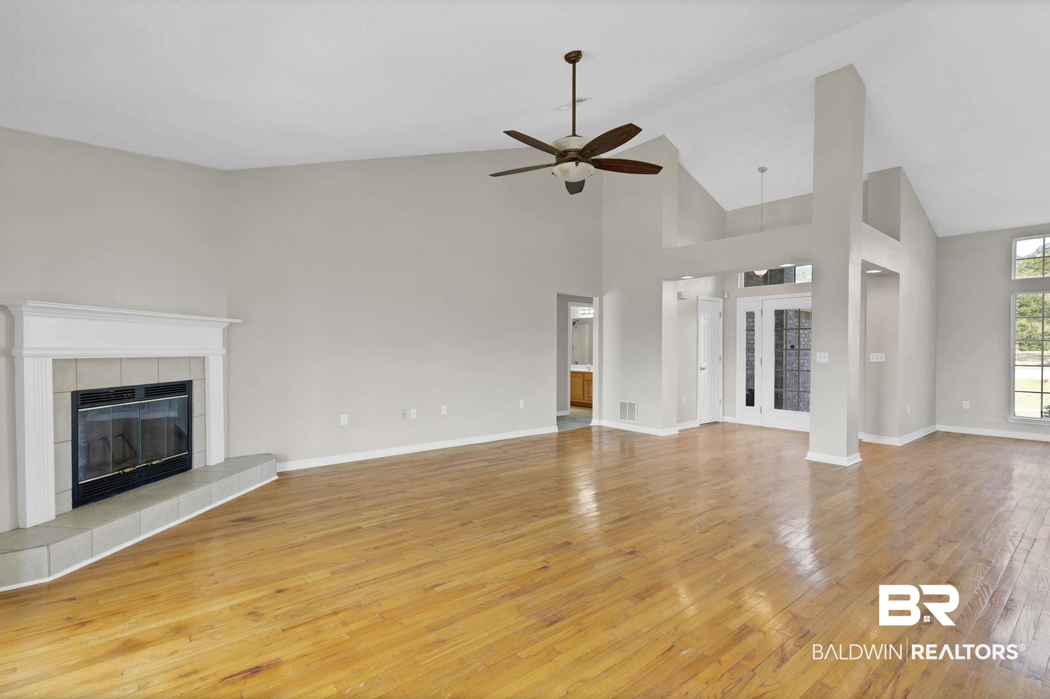 10238 Grove Drive Fairhope, AL 36532 - Photo 7 of 39 Living room Cathedral ceilings , a woodburning fireplace, ceiling fan, and light hard wood flooring
