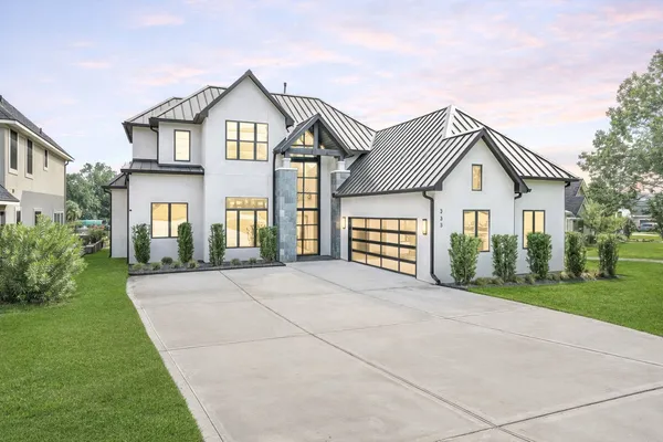 a front view of a house with a garden and yard