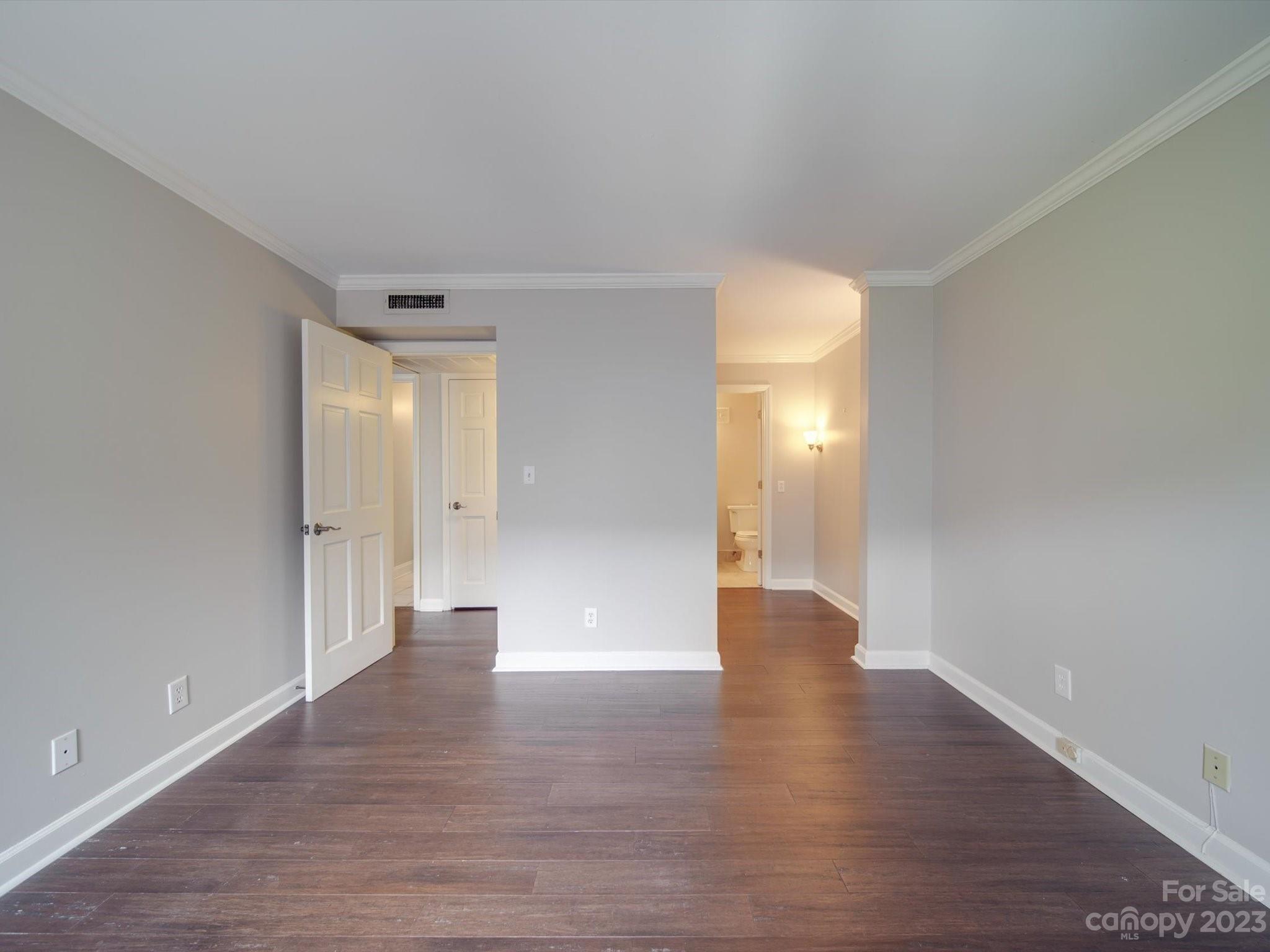 1323 Queens Road, Unit 402 Charlotte, NC 28207 - Photo 12 of 26 a view of an empty room with wooden floor and windows