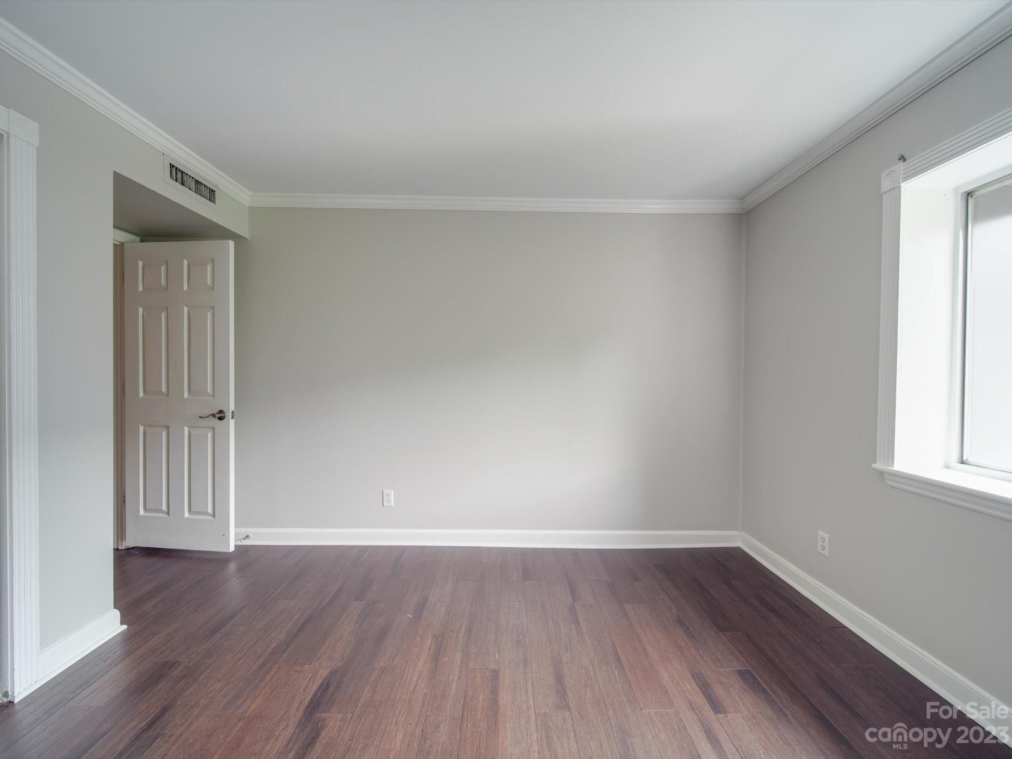 1323 Queens Road, Unit 402 Charlotte, NC 28207 - Photo 15 of 26 a view of an empty room with wooden floor and a window