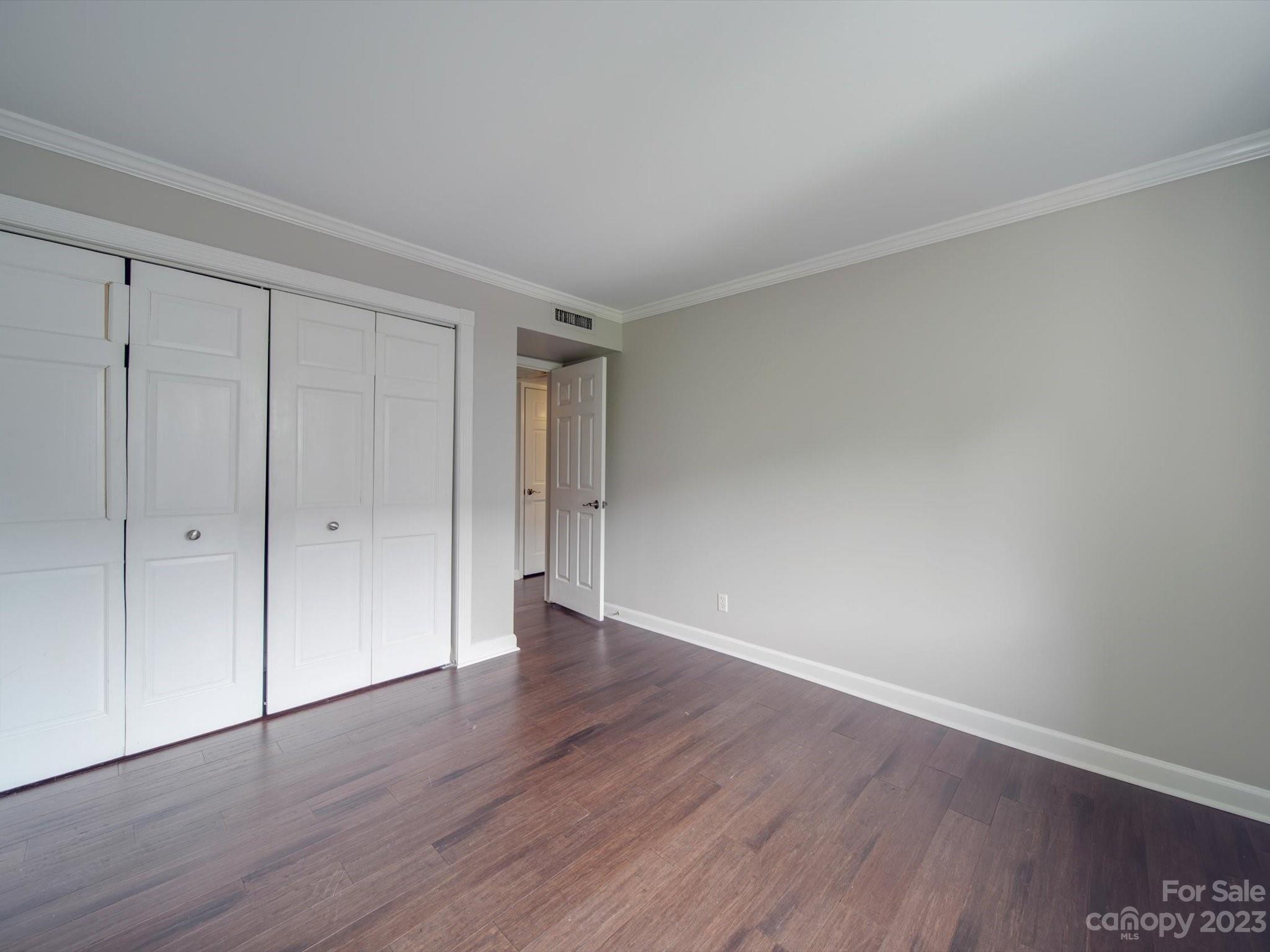 1323 Queens Road, Unit 402 Charlotte, NC 28207 - Photo 16 of 26 a view of an empty room with wooden floor