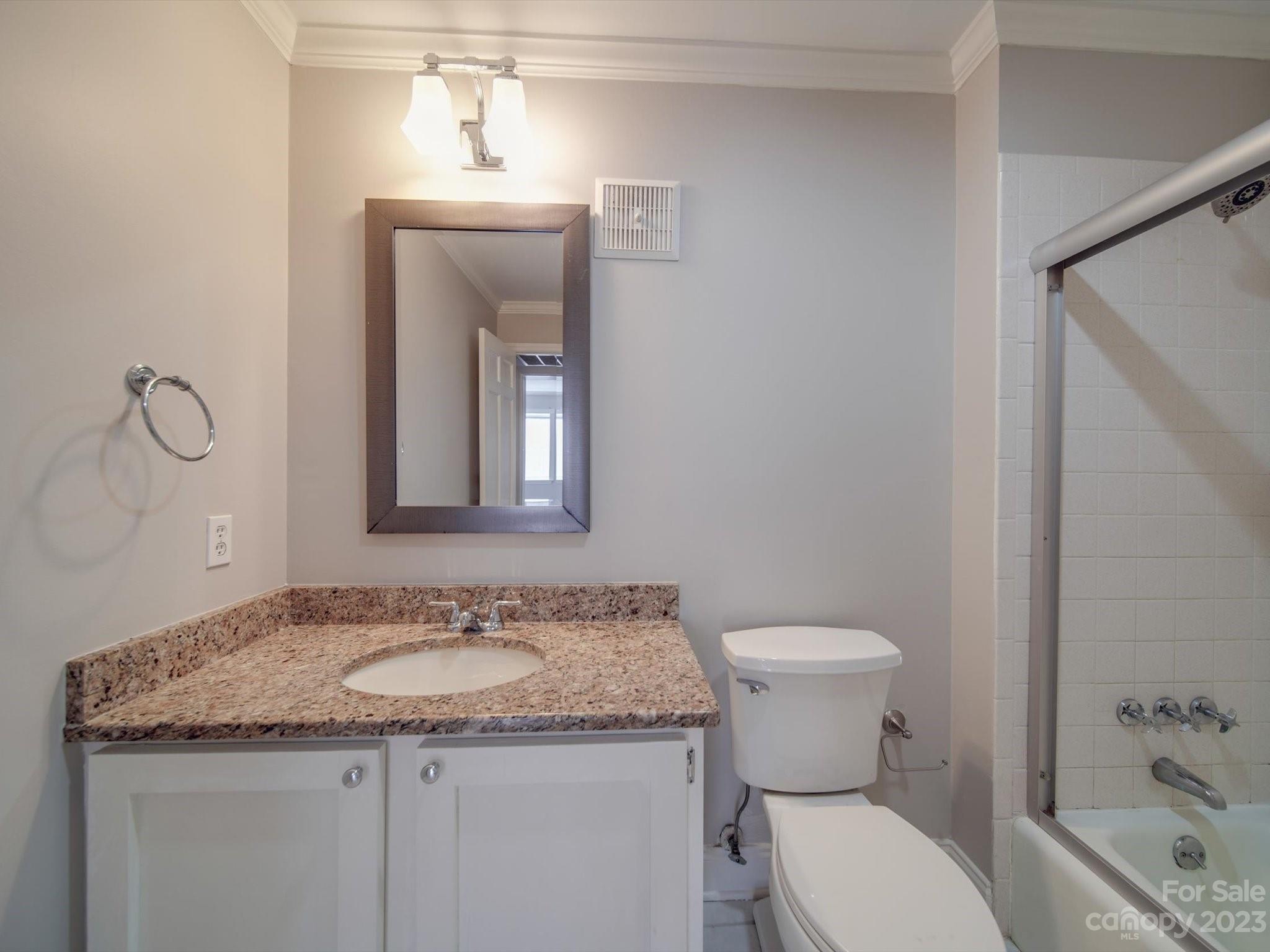 1323 Queens Road, Unit 402 Charlotte, NC 28207 - Photo 17 of 26 a bathroom with a granite countertop sink toilet and shower