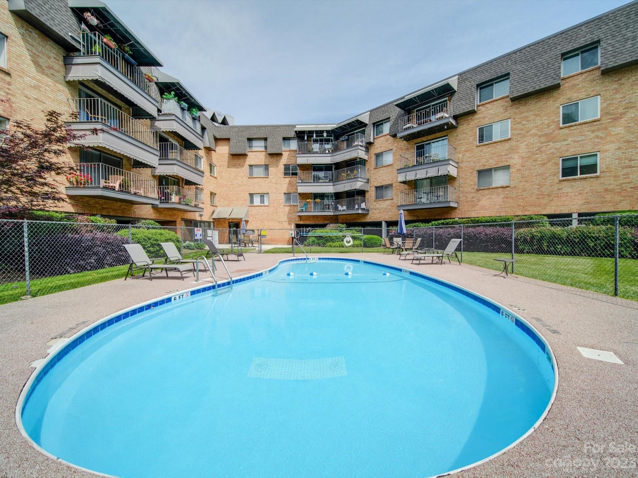 1323 Queens Road, Unit 402 Charlotte, NC 28207 - Photo 23 of 26 a swimming pool with outdoor seating and yard