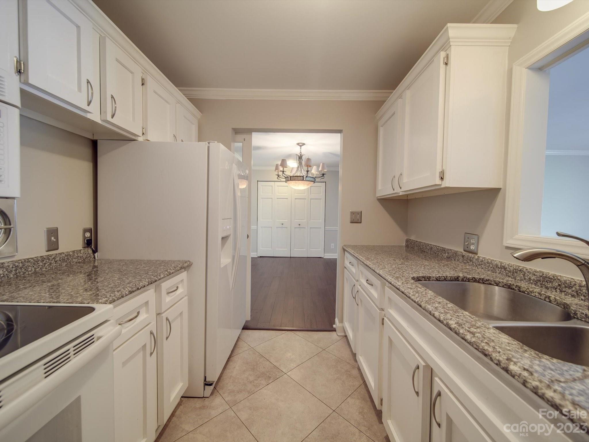 1323 Queens Road, Unit 402 Charlotte, NC 28207 - Photo 3 of 26 a kitchen with granite countertop a sink stove and refrigerator