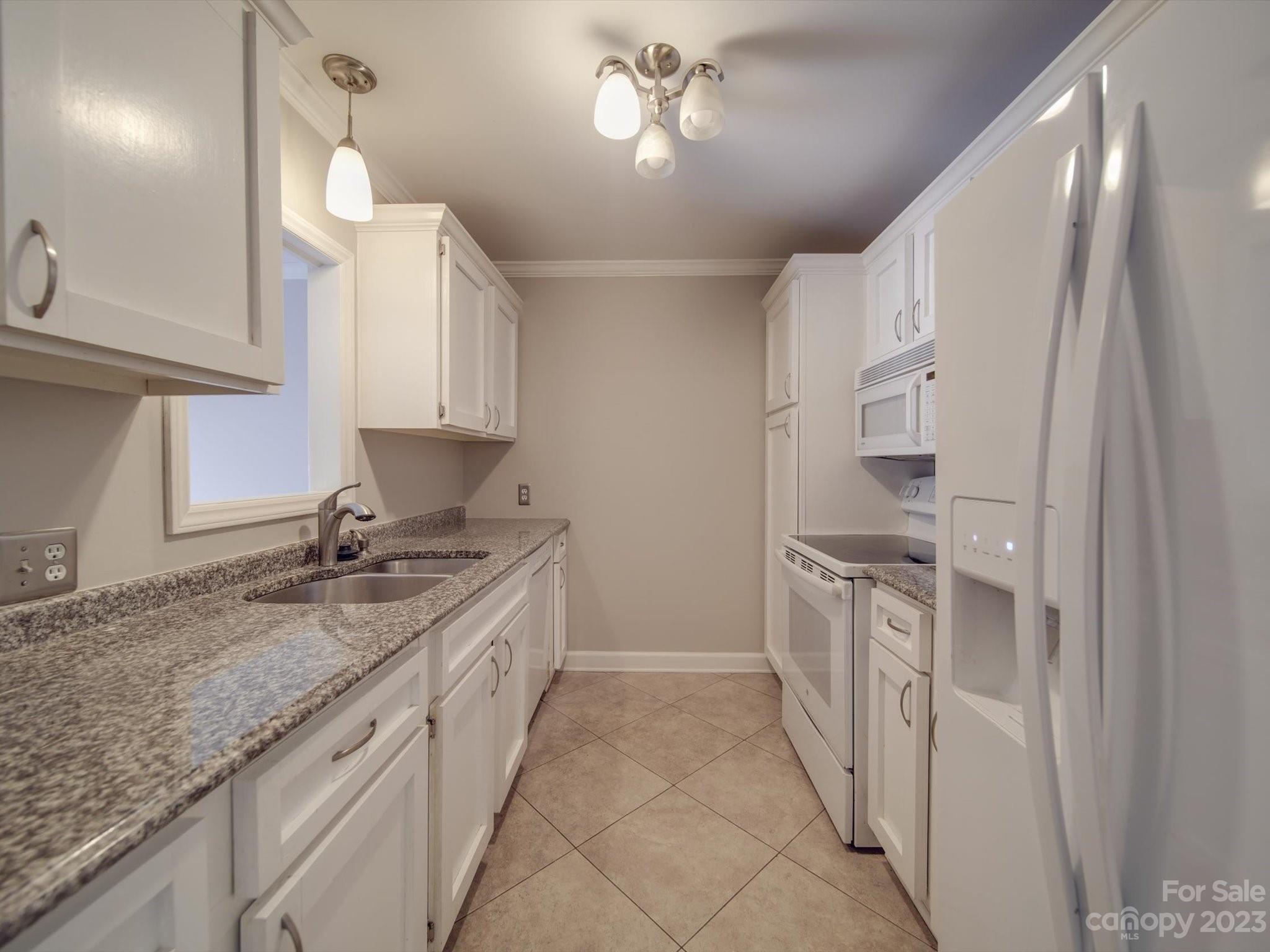 1323 Queens Road, Unit 402 Charlotte, NC 28207 - Photo 4 of 26 a kitchen with a sink and cabinets