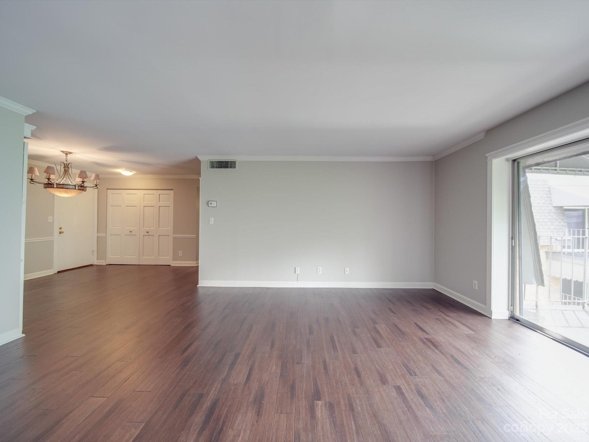 1323 Queens Road, Unit 402 Charlotte, NC 28207 - Photo 6 of 26 a view of empty room with wooden floor and fan