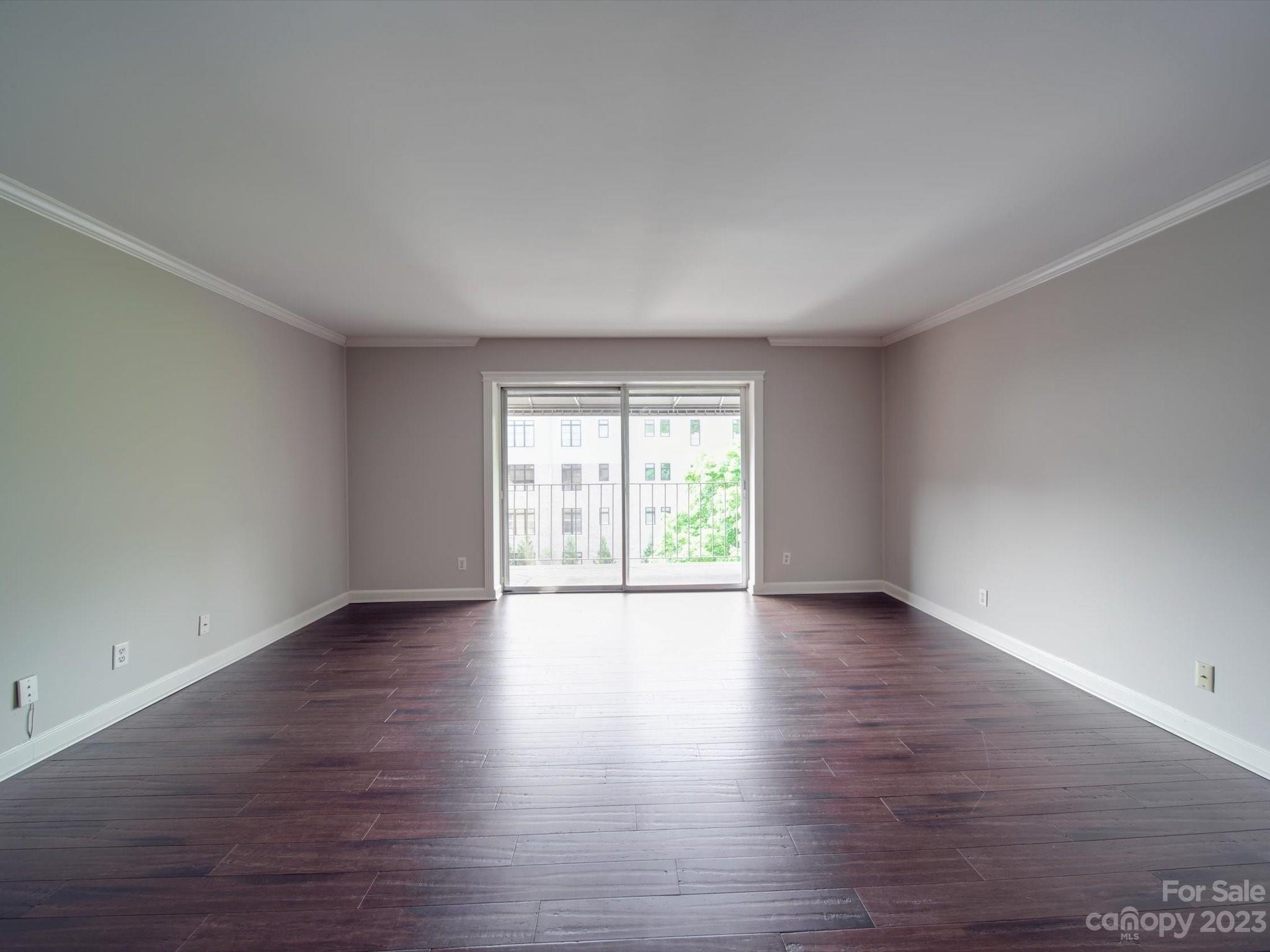 1323 Queens Road, Unit 402 Charlotte, NC 28207 - Photo 9 of 26 a view of an empty room with wooden floor and a window